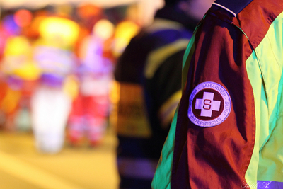 Ein sanitäter in einer leuchtenden Uniform mit einem Abzeichen des Samariterbunds.