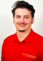 Ein junger Mann mit einem roten Polo-Shirt lächelt freundlich in die Kamera.