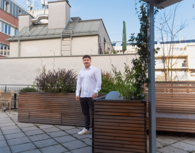 Ein Zivildienstleistender steht in Zivilkleidung auf einer Terrasse.