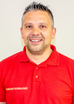 Lächelnder Mann in rotem Polohemd mit dem Aufdruck „Samariterbund“.