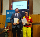 Zwei Personen halten Auszeichnungen beim Camillo Award 2023 im Parlament.