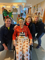 Vier Personen, darunter eine Frau im Rollstuhl, feiern festlich.