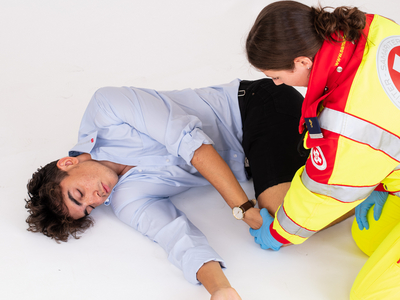 Sanitäterin bringt Patient in die stabile Seitenlage.